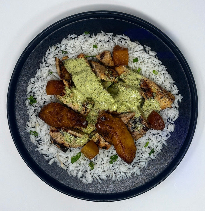 Plated dish with rice, chicken, and vegetables on a white background