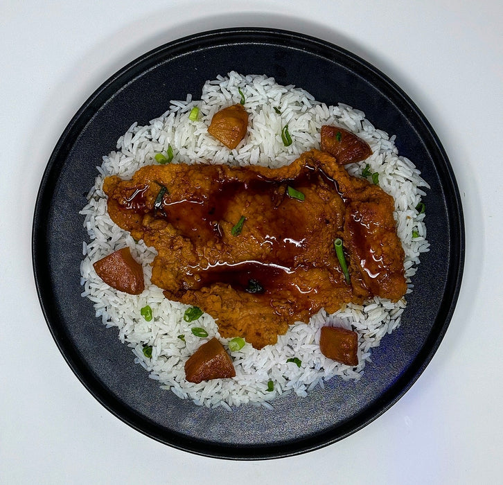 Plated dish of rice with browned meat pieces on a white background. spartan meal preps paramus new jersey meal prep comapny.