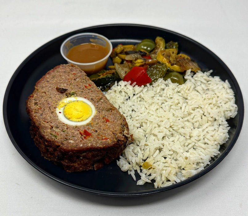 A plate with stuffed meatloaf, jasmine rice, and a veggie mix, served with a side of sauce. A Meal made by spartan meal Prep, a meal prep company in Lodi new jersey.