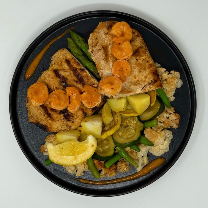 Plated dish with grilled bread, vegetables, and sliced carrots on a white background