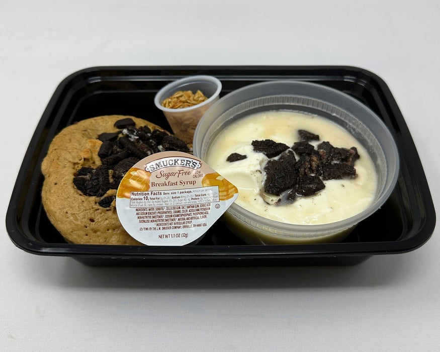 A plate with two high protein pancakes topped with Oreo pieces, alongside a protein Greek yogurt parfait in a clear container.