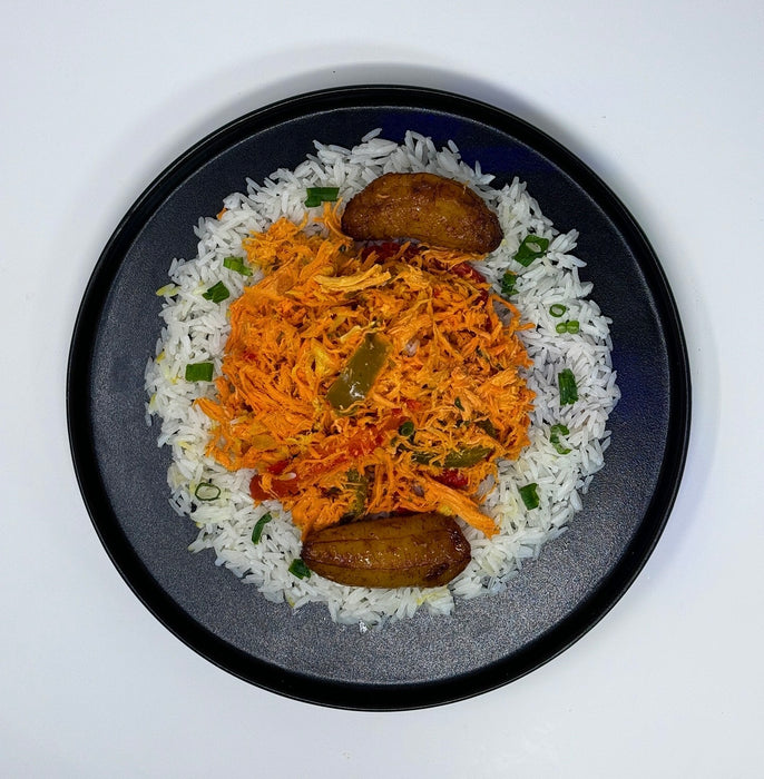 Plate of food with rice, orange dish, and green vegetables on a white background