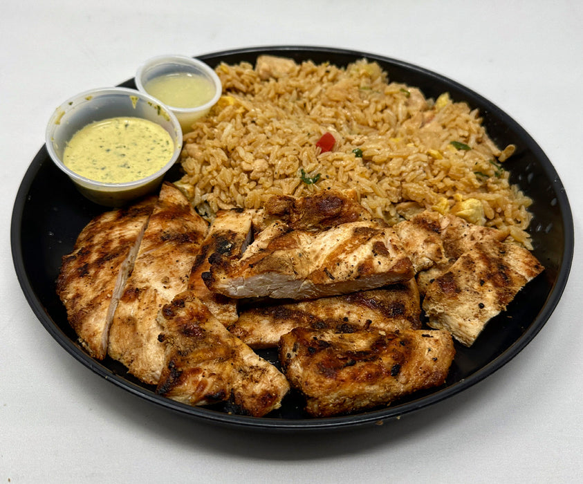 A plate of grilled chicken breast with garlic powder and a side of Spartan Chaufa rice, accompanied by a cup of house signature chaufa sauce.