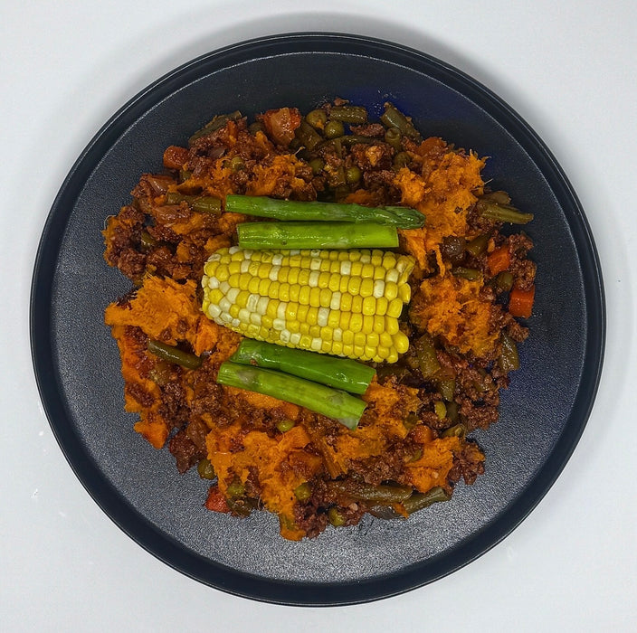 Plated dish with corn on the cob and green beans on a white background