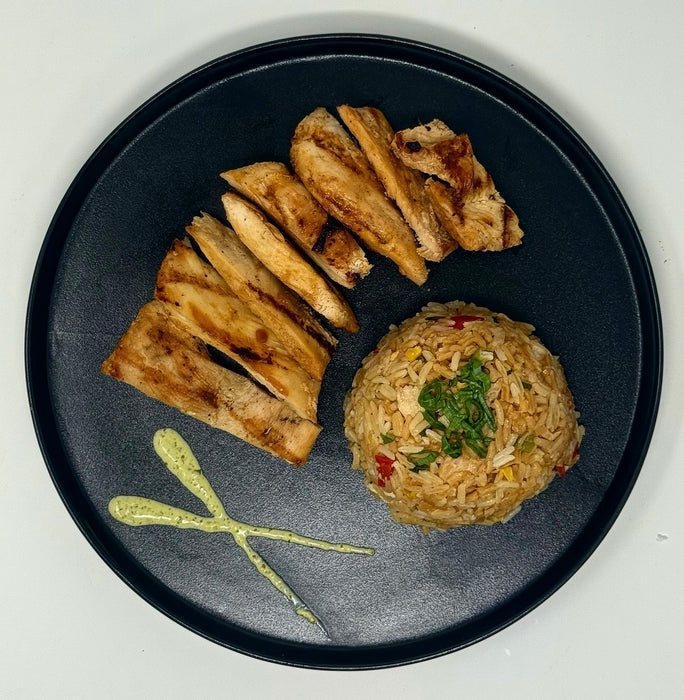 Black plate with grilled bread slices and a ball of fried rice on a white background