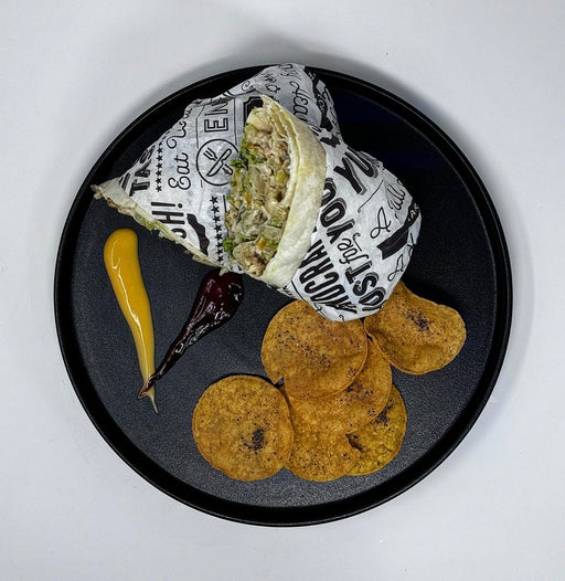 Wrap with tortilla chips and condiments on a black plate