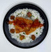 Plated dish with rice, fried chicken, and sauce on a white background