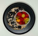 Black plate with a dessert and a container of fruit salad on a white background