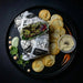 Wrap with vegetables on a black plate with chips and dip, on a dark background