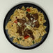 Pasta dish with meat and vegetables on a black plate
