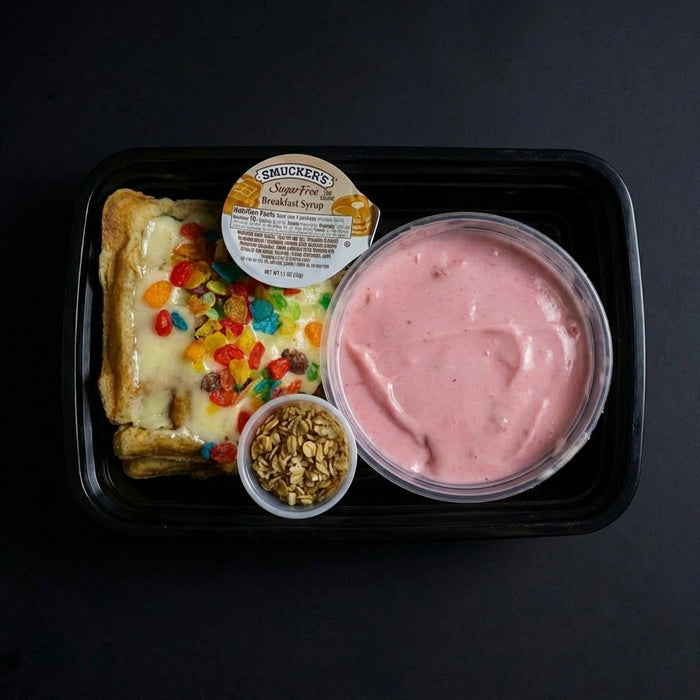 Prepared meal with dessert item, yogurt, and granola in a black tray on a dark background