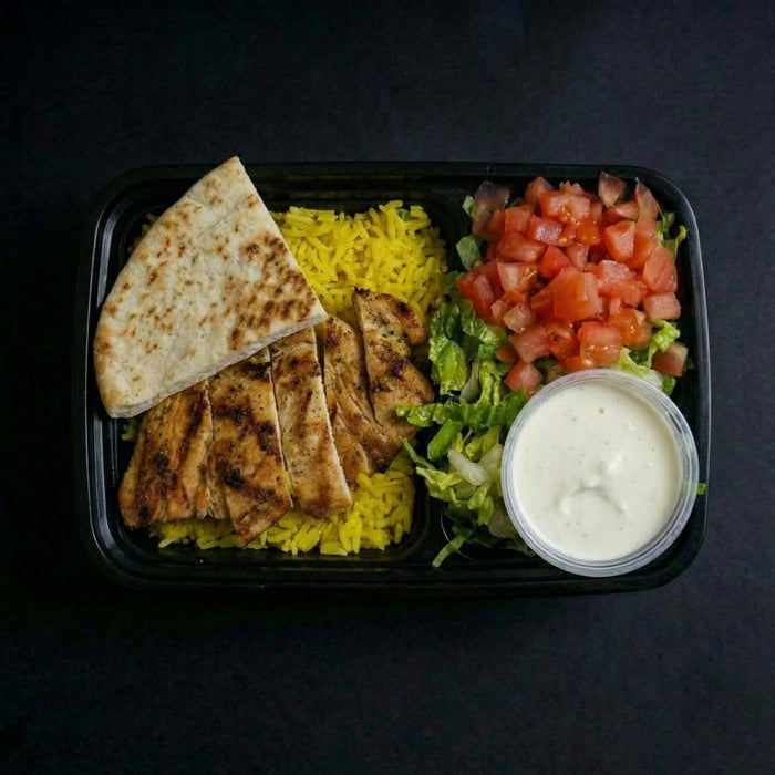 Plated meal with rice, salad, and flatbread on a dark background