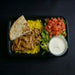 Plated meal with rice, salad, and flatbread on a dark background