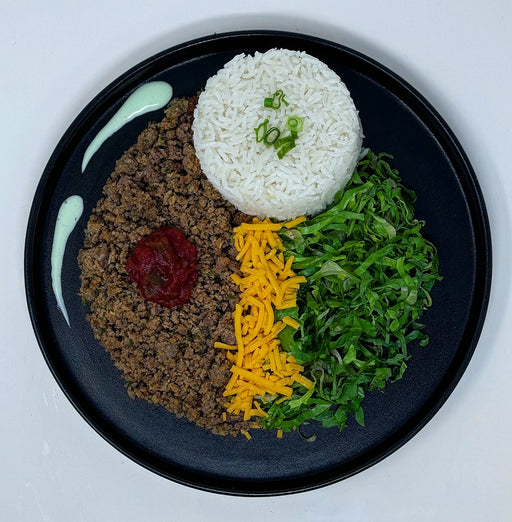 ground beef paired with jasmine rice, cheese and lettuce topped with a house sauce all served on a black plate. Meal made by spartan meal preps nj.  