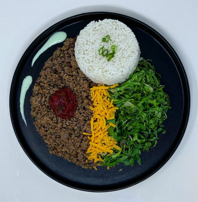 ground beef paired with jasmine rice, cheese and lettuce topped with a house sauce all served on a black plate. Meal made by spartan meal preps nj.  