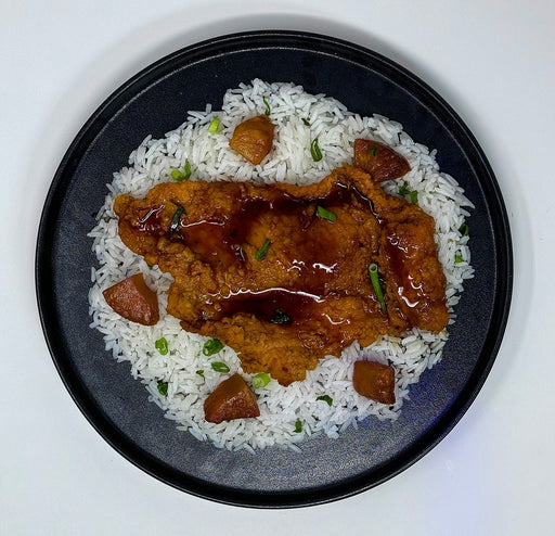 Plated dish of rice with browned meat pieces on a white background. spartan meal preps paramus new jersey meal prep comapny.
