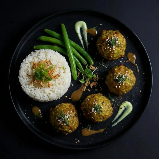Plated dish with rice, green beans, and meatballs on a dark background