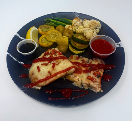 Plated dish with pizza, vegetables, and sauces on a blue plate.