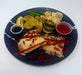 Plated dish with pizza, vegetables, and sauces on a blue plate.