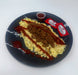 Plate with a serving of macaroni and cheese, brown sauce, and a small container on a white background