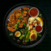 Plated dish with grilled chicken, vegetables, and sauces on a dark background