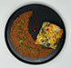 Two dishes on a black plate: one with brown ground meat and green vegetables, the other with a colorful vegetable omelette.