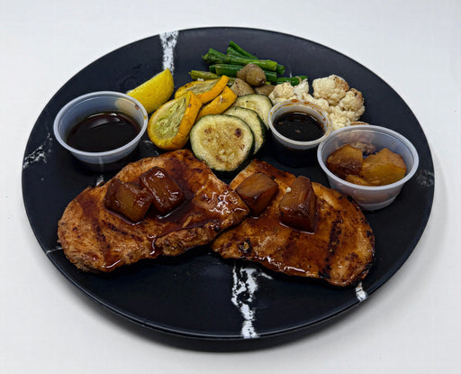Plated dish with grilled meat, vegetables, and sauces on a black plate. a meal made by spartan meal preps.