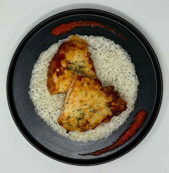 Plated dish with rice, fried chicken, and red sauce on a white background