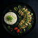 Plated dish with rice, chicken, and vegetables on a dark background