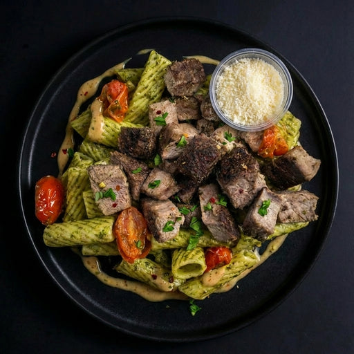 Plated dish of pasta with meat and vegetables on a dark background. Meal made by spartan meal preps