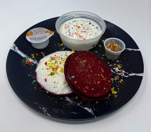 Two colorful pancakes on a black marble plate with side dishes. A meal made by spartan meal preps a nj new york meal delivery service.