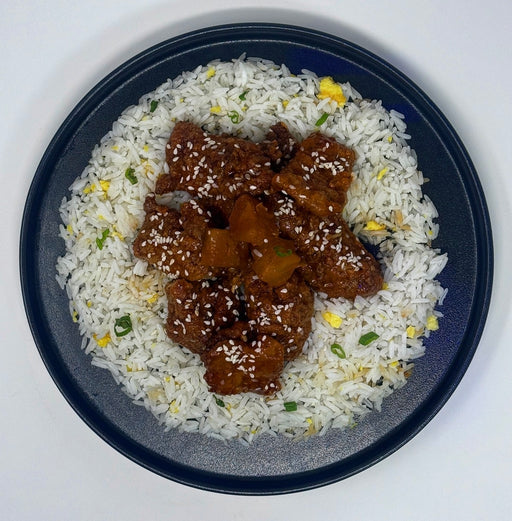 Bowl of rice with fried chicken pieces on a white background. A Jersey City, NJ, meal prep company. 