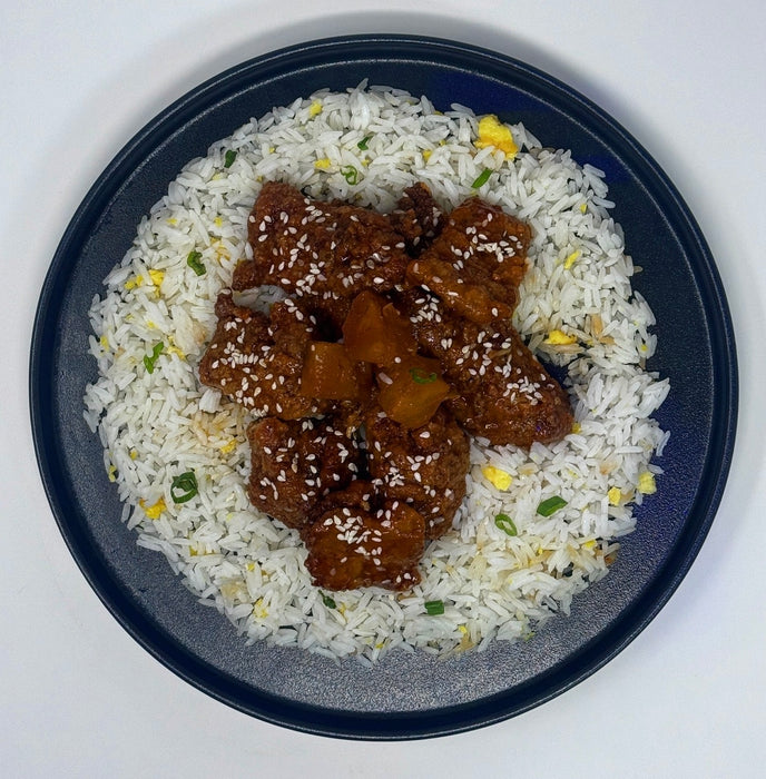 Bowl of rice with fried chicken pieces on a white background. A Jersey City, NJ, meal prep company. 