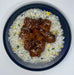 Bowl of rice with fried chicken pieces on a white background. A Jersey City, NJ, meal prep company. 