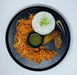 Plated dish with rice, fried plantains, and shredded carrots on a black plate.
