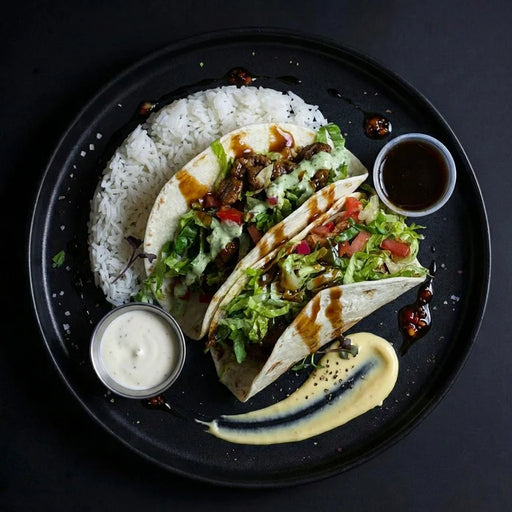 Tacos with rice and sides on a black plate. A meal made by spartan meal preps nj.