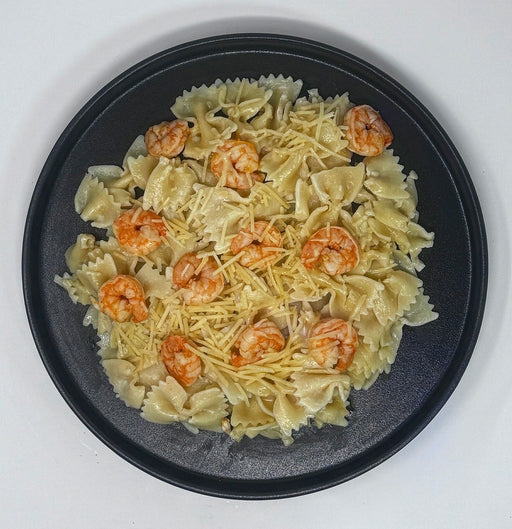 Pasta with shrimp on a black plate