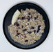 Oatmeal with dried fruits and a banana on a black plate