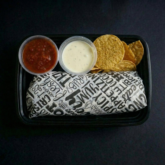 Tray with a burrito, salsa, sour cream, and tortilla chips on a dark background