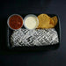 Tray with a burrito, salsa, sour cream, and tortilla chips on a dark background