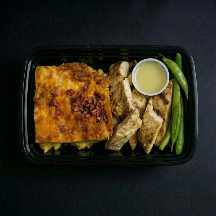 Plated meal with breaded dish, chicken, and green beans on a dark background