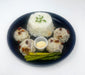 Plated dish with rice, meatballs, and asparagus on a white background