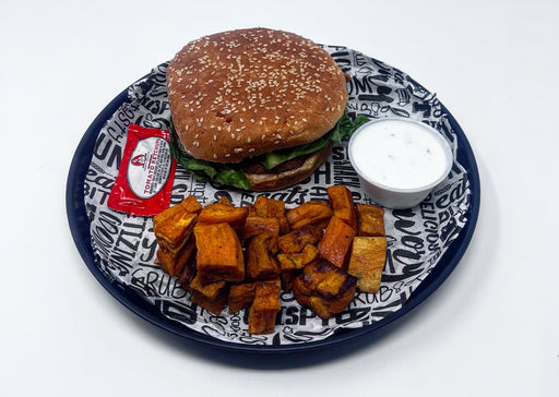 Burger with fries and a side of sauce on a decorative plate
