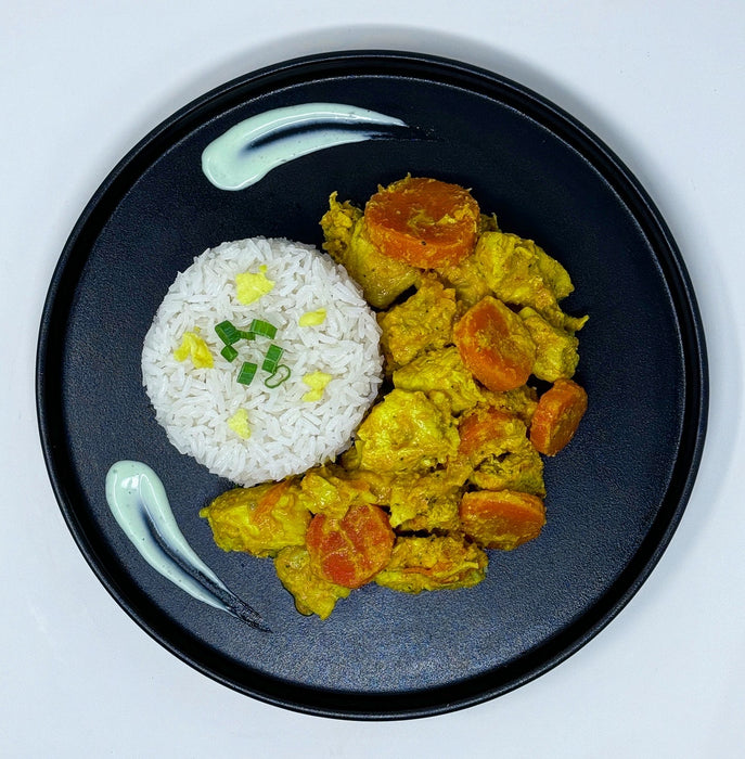 Spartan meal preps - Curry Chicken - NJ Meal Prep Delivery - Curry chicken paired with green beans and carrots and rice on a black plate.