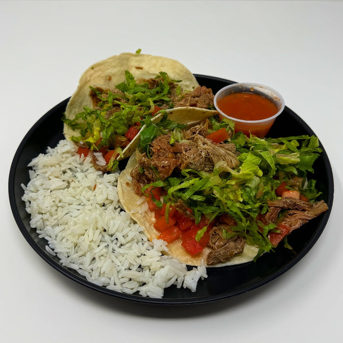 Spartan meal preps - Shredded steak tacos - nj meal prep - two tacos paired with rice and sauce cup on a black plate. 
