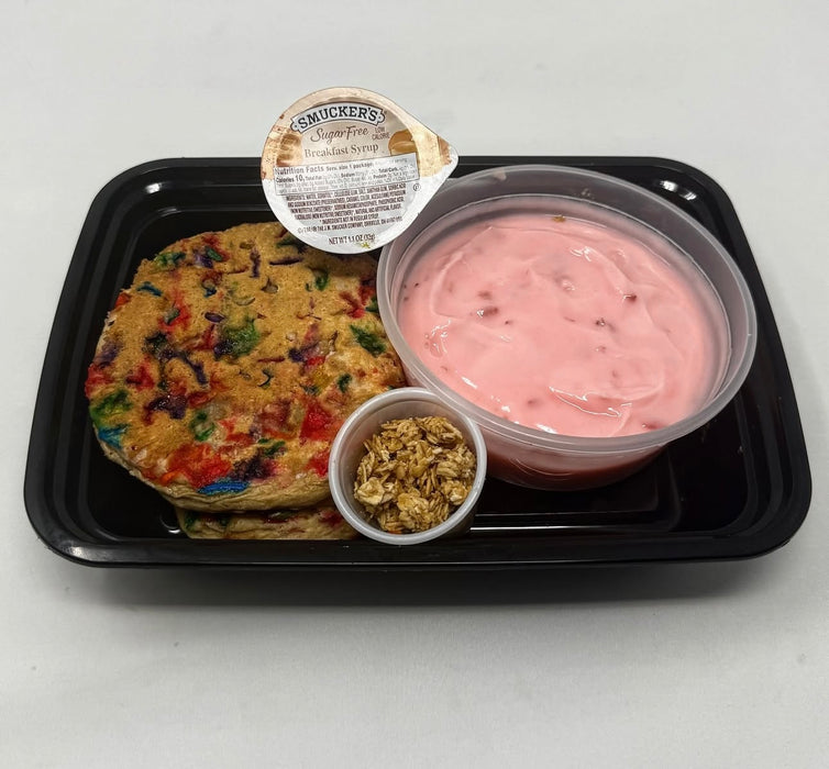 Spartan meal preps nj - birthday cake protein pancakes paired with strawberry yogurt, granolla and a sugar free syrup cup on a black plate