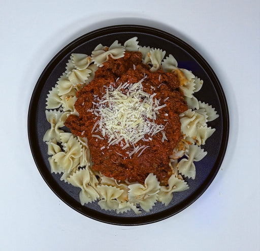 Pasta dish with red sauce and grated cheese on a black plate