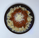 Pasta dish with red sauce and grated cheese on a black plate