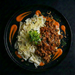 Plated dish with pasta and ground meat on a dark background