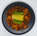 Plated dish with corn on the cob and green beans on a white background